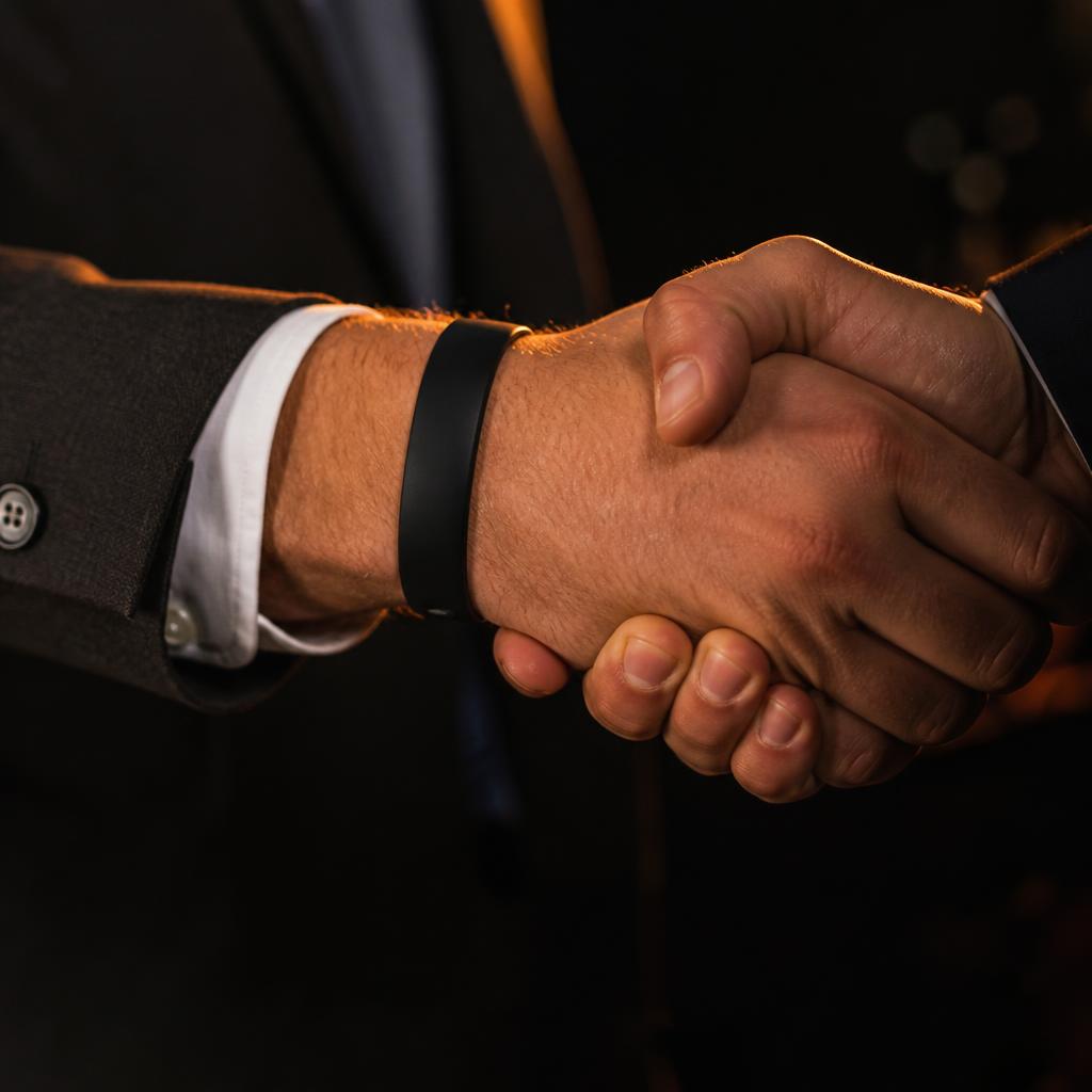 Aperto de mãos com pulseira de silicone preta no pulso
